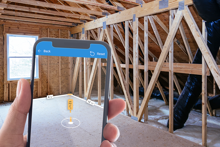 A photo of a phone screen that shows dimensions overlaid on a corner in a room that's under construction.