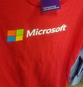 Fotografía de una camiseta roja con una etiqueta y el logotipo de Microsoft.