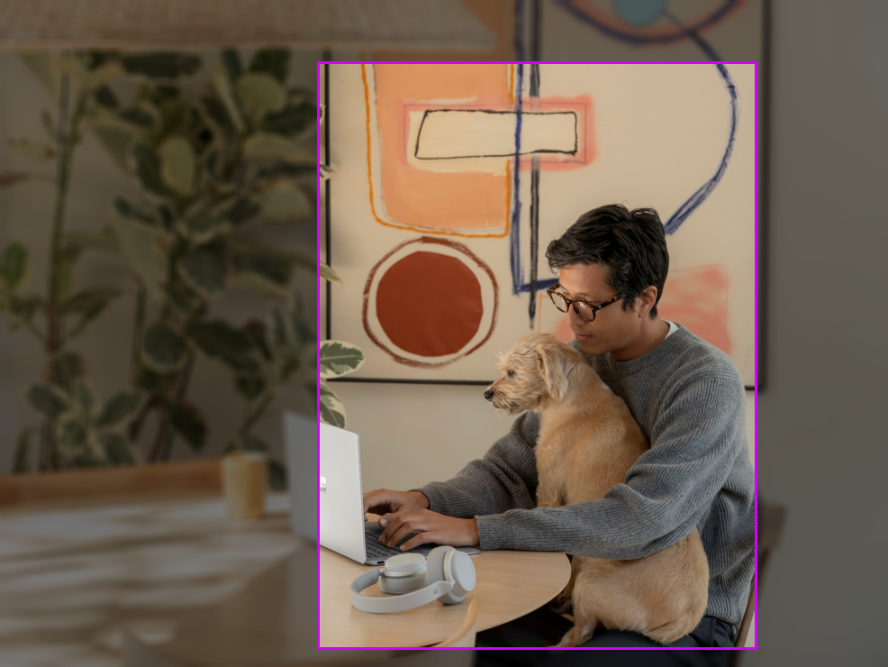 Foto di un uomo con un cane seduto a un tavolo. Viene disegnato un rettangolo di delimitazione con rapporto di 0,75.