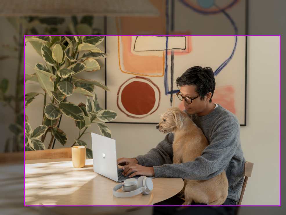 Foto di un uomo con un cane seduto a un tavolo. Viene disegnato un rettangolo di delimitazione con rapporto di 1,50.